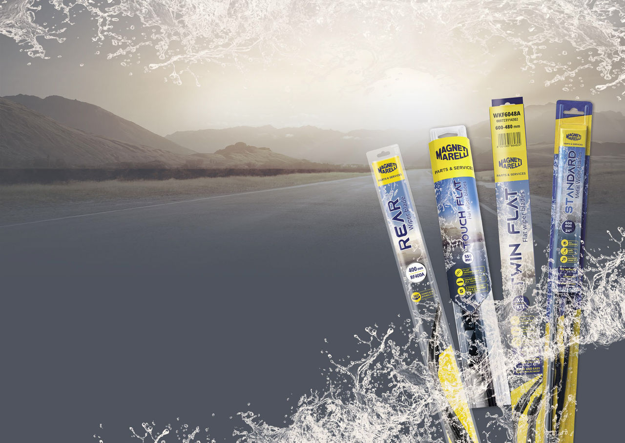 Quatre modèles de balais d'essuie-glaces Magneti Marelli dans leur emballage, avec une route de montagne en arrière-plan et des gouttes d'eau simulant la vision à travers un pare-brise propre.